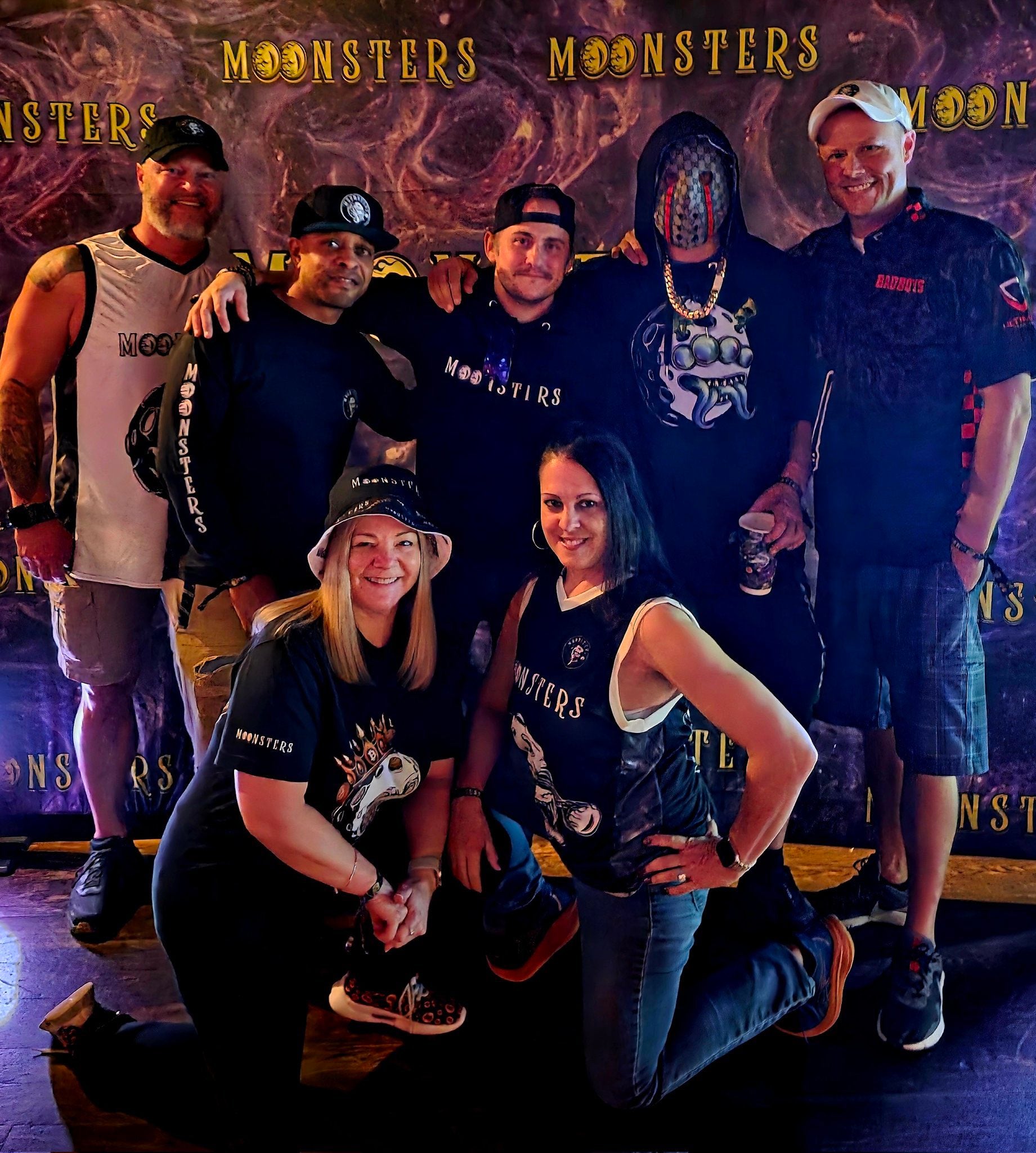 Group of people posing in front of a 'Moonsters' themed backdrop at Moonsters NFT NYC Manhattan event.