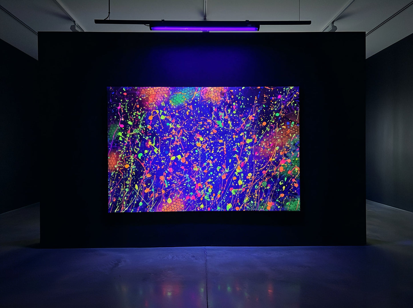 Abstract neon artwork with vibrant splatters of blue, pink, orange, and green on a dark background.