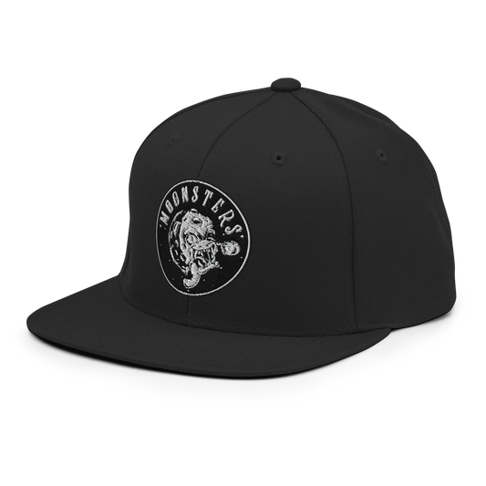 Black snapback hat with a flat brim and white circular "Moonsters" logo featuring a Moonsters graphic on the front panel.